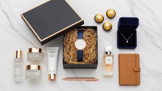 A curated flat lay of luxury teen gifts including a designer watch, premium skincare set, and elegant gift box on a marble surface
