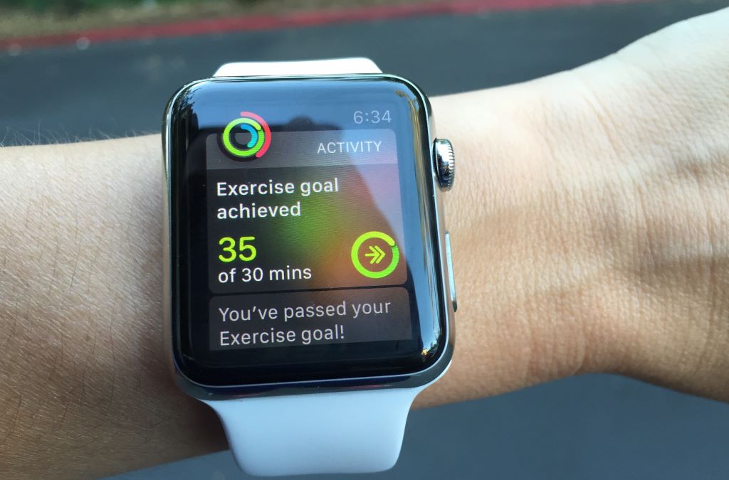 Person checking fitness progress and step count on a smartwatch during a workout