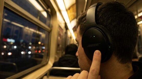 Bose QuietComfort headphones charging on a wooden table