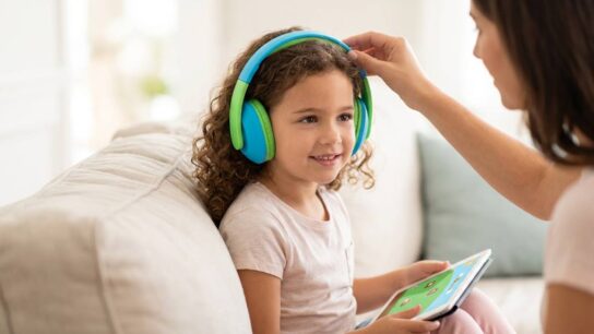 Child wearing noise cancelling headphones while studying at a desk