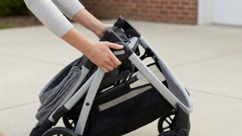 Parent converting Graco Modes toddler seat into lie-flat newborn pramette carriage in park.