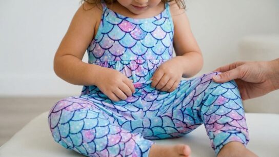 Toddler girl wearing a cotton Vieille jumpsuit while playing outdoors
